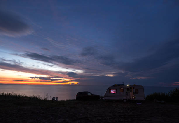 istock camping, mobile home on the beach, green grass, twilight 844447088