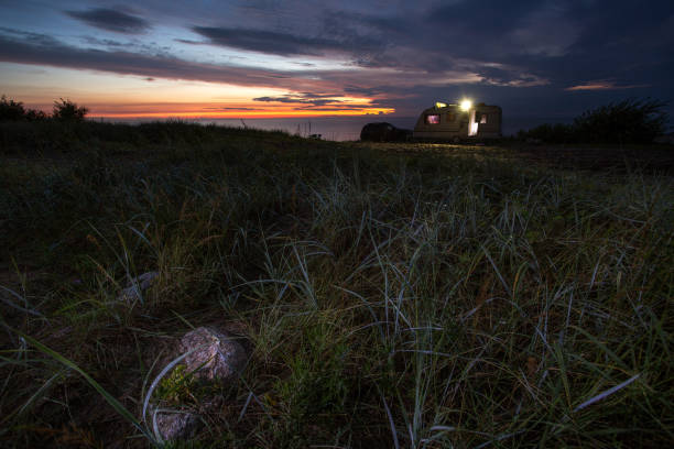 istock camping, mobile home on the beach, green grass, twilight 844447096