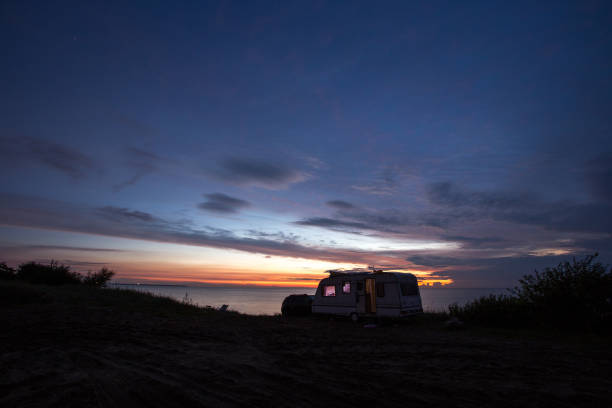 istock camping, mobile home on the beach, green grass, twilight 844447100