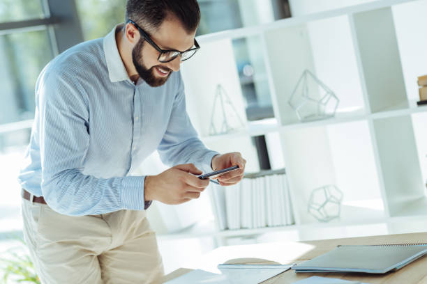istock Charming office worker taking photos of printouts 844451538