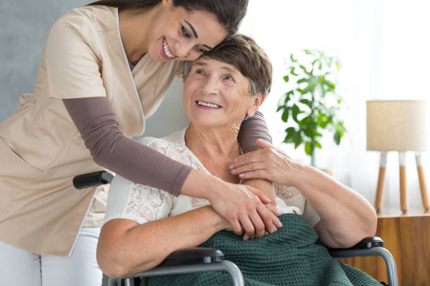 lady proud of her granddaughter - senior adult wheelchair community family imagens e fotografias de stock