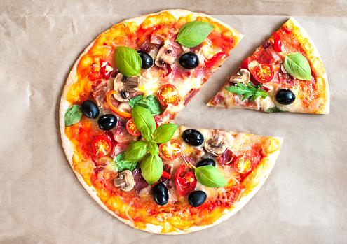 Pizza Margherita with cheese and basil leaf on baking craft paper background with fresh ingredients   for you to design and restaurant menu. Delicious Homemade Cheese  pizza\