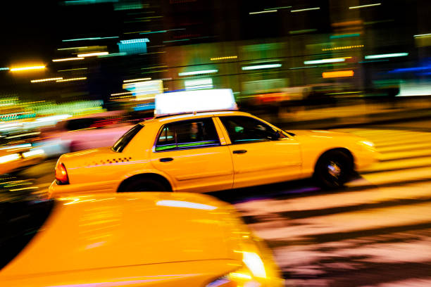 Yellow cab with panning motion at night in Manhattan Yellow cab with panning motion at night in Manhattan, New York City car city urban scene commuter stock pictures, royalty-free photos & images