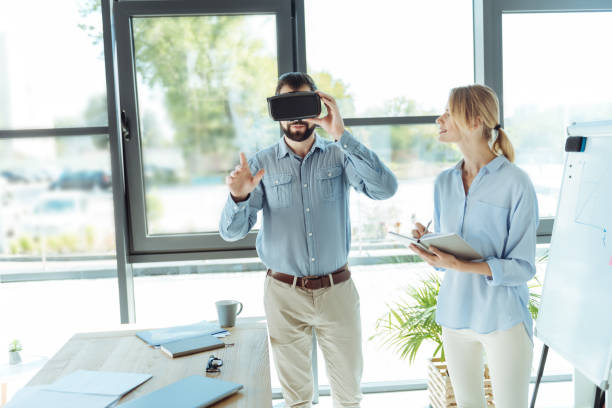 istock Bearded young man wearing VR headset in the office 844459048