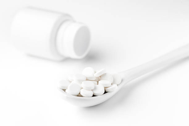 istock Pills on the spoon and scattered on the white surface 844459962