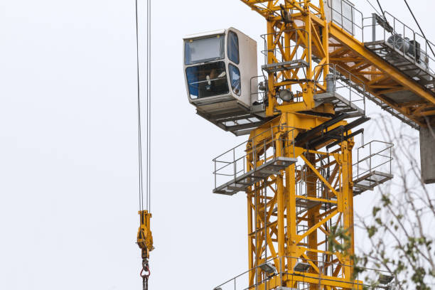 istock Construction crane - yellow metal tower and white cabin - close up 844472470