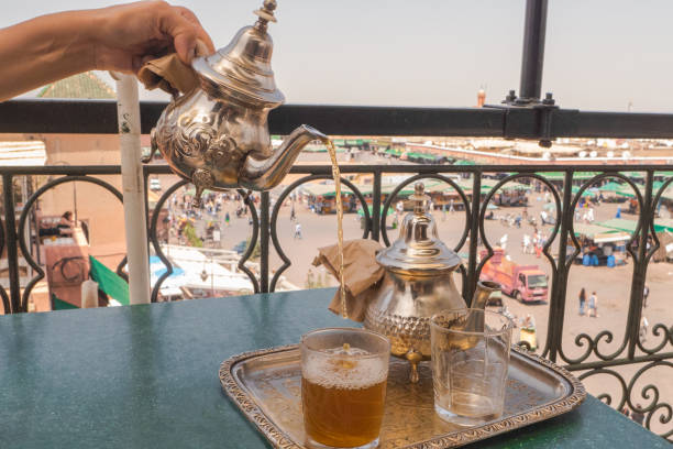 avere un tradizionale tè alla menta a marrakech, in marocco. - morocco tea glass mint tea foto e immagini stock