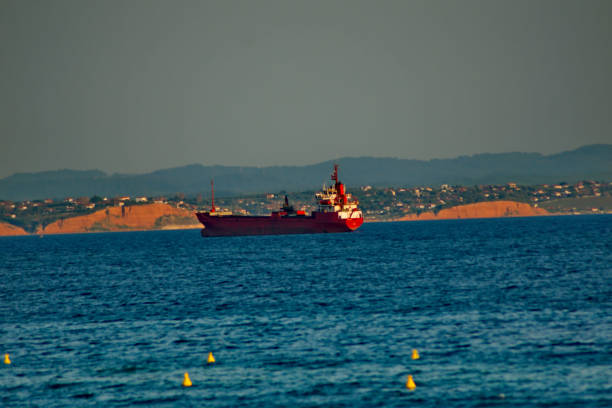 A big oil tanker in a sea in a town in Greece,Nea Moudania,and mountains in the background,in a summer day of August