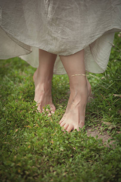 Woman legs standing in grass on summer meadow stock photo