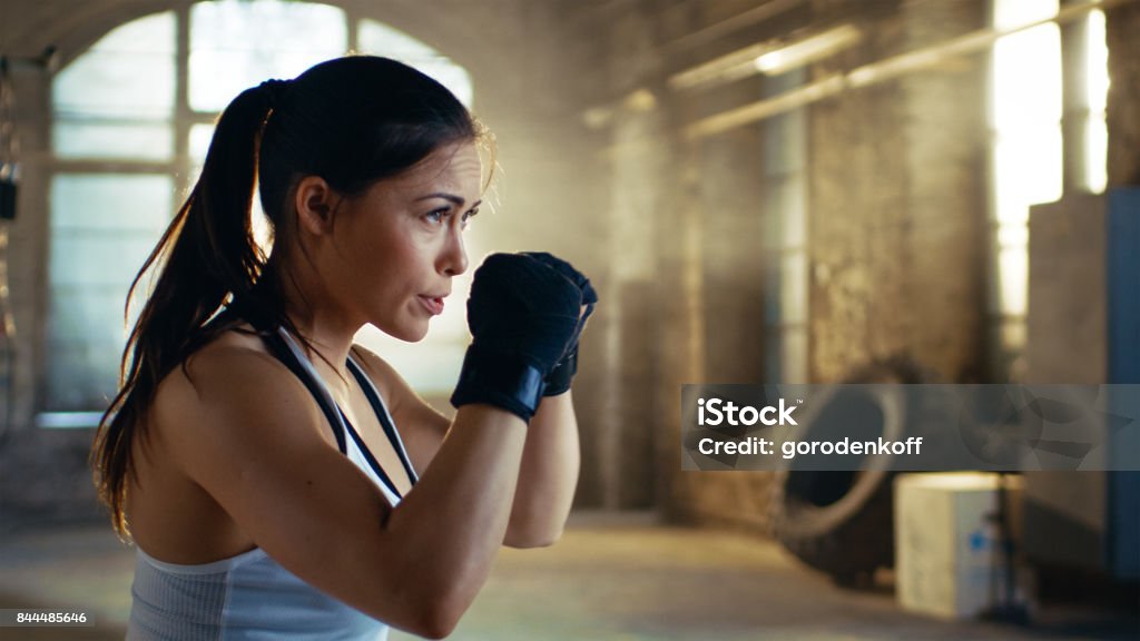 Hermosa mujer atlética sostiene sus brazos listos para defender a sí misma. Es una parte de su Cross Fitness Gimnasio entrenamiento intensivo. - Foto de stock de Boxeo - Deporte libre de derechos