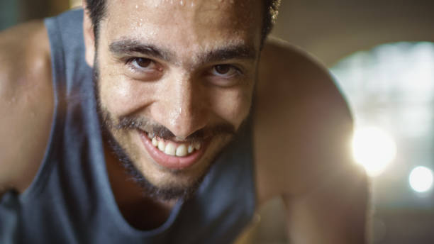 Exhausted Bend Muscular Man Looks into Camera and Rests After Intensive Workout. He's In a Gym and Covered in Sweat. He Tries to Catch a Breath. Exhausted Bend Muscular Man Looks into Camera and Rests After Intensive Workout. He's In a Gym and Covered in Sweat. He Tries to Catch a Breath. people laughing hard stock pictures, royalty-free photos & images
