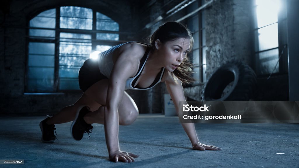 Athletic Beautiful Woman Does Push-ups as Part of Her Cross Fitness, Bodybuilding Gym Training Routine. Women Stock Photo