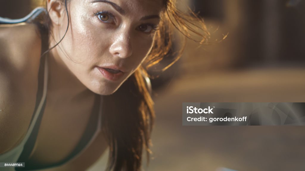 Lo scatto ravvicinato di una bella donna atletica guarda nella telecamera. È stanca dopo un intenso esercizio di fitness incrociato. - Foto stock royalty-free di Donne