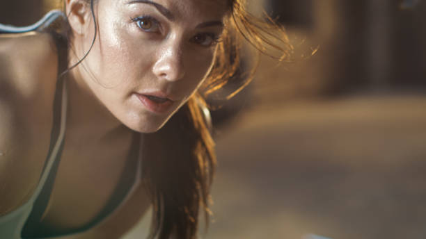 Close-up Shot of a Beautiful Athletic Woman Looks into Camera. She's Tired after Intensive Cross Fitness Exercise. Close-up Shot of a Beautiful Athletic Woman Looks into Camera. She's Tired after Intensive Cross Fitness Exercise. rubbing photos stock pictures, royalty-free photos & images