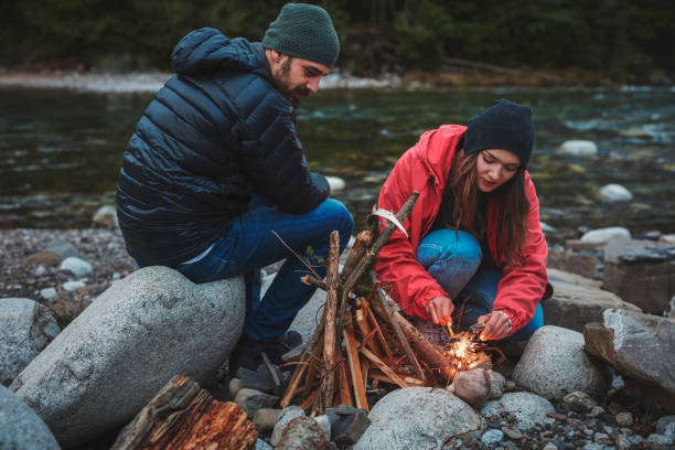 istock Young couple burning the campfire. Mountainous landscape 844489412