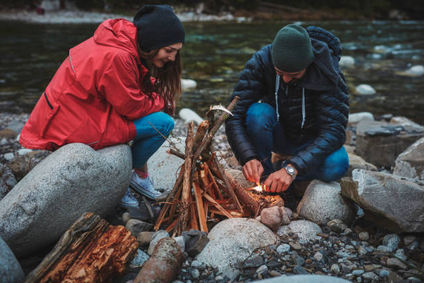 istock Young couple burning the campfire. Mountainous landscape 844497284
