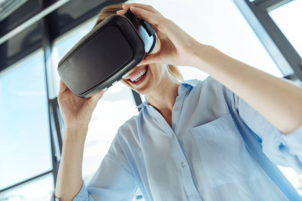 istock Cheerful young woman wearing a VR headset 844500324