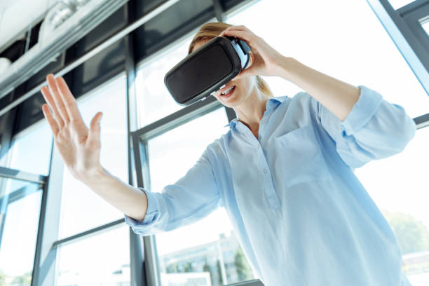 istock Young woman in VR headset stretching out her hand 844500376