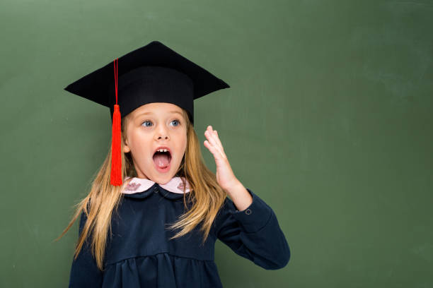 shouting schoolgirl in graduation hat shouting schoolgirl in graduation hat next to chalkboard blackboard child shock screaming stock pictures, royalty-free photos & images