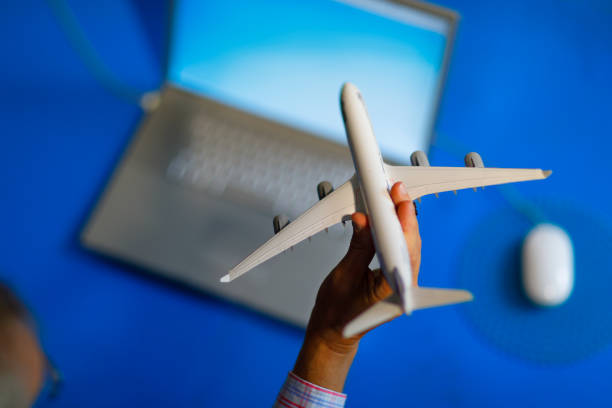 istock Flight booking on laptop with aircraft scale model at home. 844504538