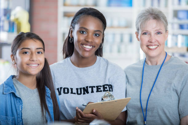 diverse mixed age female volunteer in food bank - to do list organization life family imagens e fotografias de stock