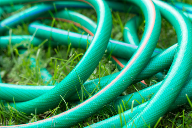A green and orange hose for watering the garden close up A green and orange hose for watering the garden close up garden hose stock pictures, royalty-free photos & images