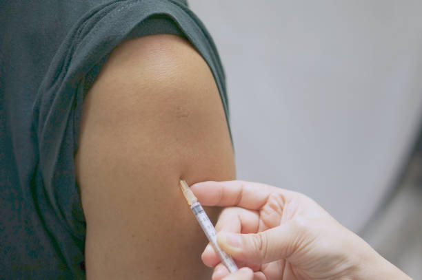 istock Nurse holding hypodermic syringe has injected vaccine with patient man 844511974