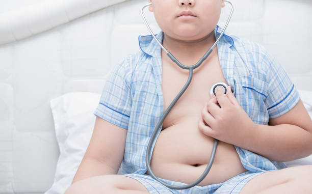 il grassone obeso controlla il cuore con lo stetoscopio, - belly button foto e immagini stock