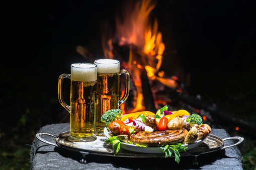 two glasses of beer on the background of fire