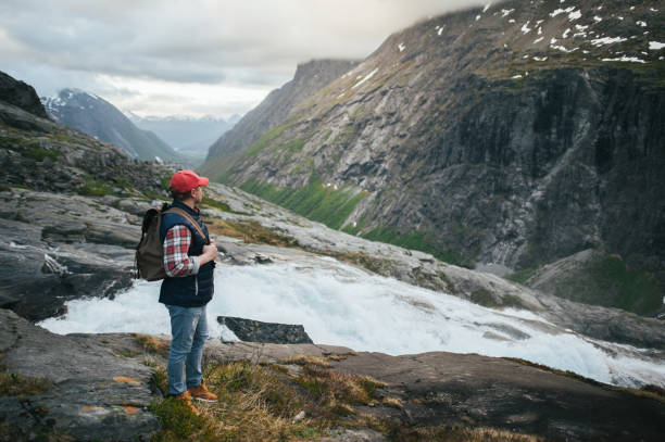 istock Man Hiker near waterfall in  mountains 844521526