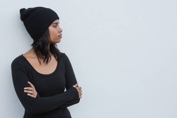 istock Thoughtful woman with arms crossed against white wall 844521766