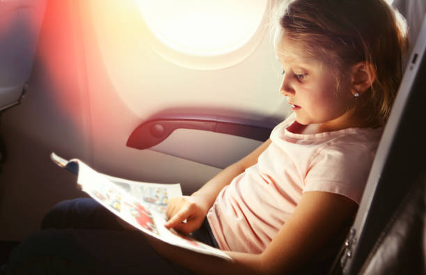 istock Young girl reading a magazine during flight 844525388