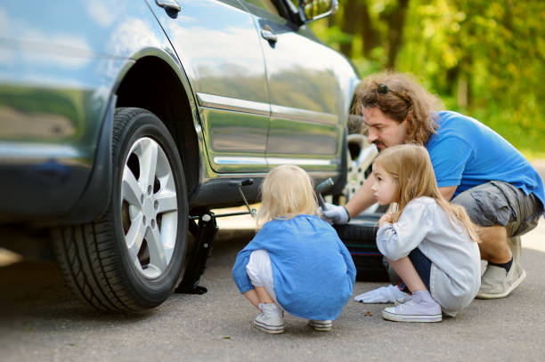 istock Happy family changing a car wheel 844525914
