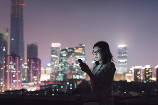 Asian Woman Using Mobile Phone in Downtown District