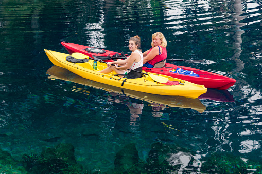 Two women kayaking in the Silver River in Silver Springs, Florida.