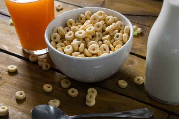 istock Cereal rings, orange juice and milk on wooden table 844539850