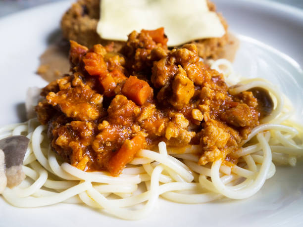 istock Spaghetti with fried chicken topped with cheese, placed on a white plate. 844543108
