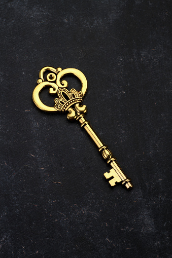 Golden Key with Crown on Black Background