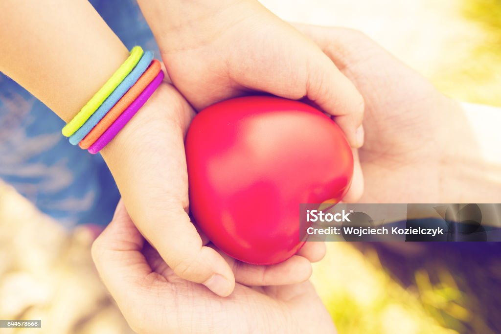 close up of child and mother hands with heart close up of child and mother hands with heart; health care, love, hope and family concept - vintage filter applied A Helping Hand Stock Photo