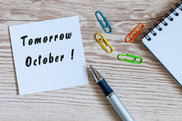 istock Tomorrow October written on a sticker at workplace. Business office concept. Autumn time 844584426