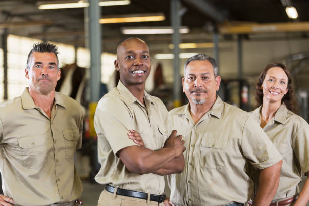 quatro trabalhadores da empresa na garagem de caminhões - truck driver multi ethnic group industry working class - fotografias e filmes do acervo