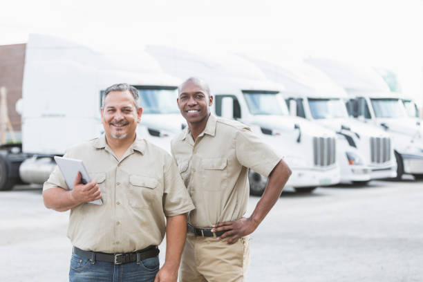 istock Multi-ethnic workers standing in front of semi-trucks 844596804