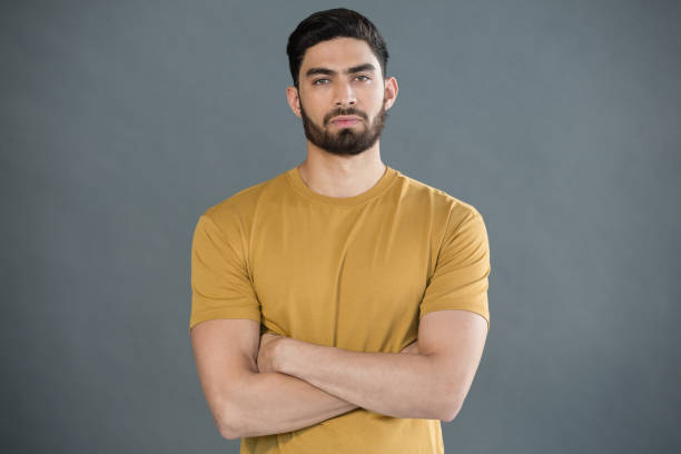 istock Handsome man posing with arms crossed against grey background 844607834