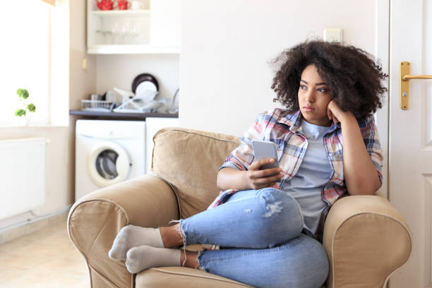 istock Young woman sitting at home and using smart phone 844622068