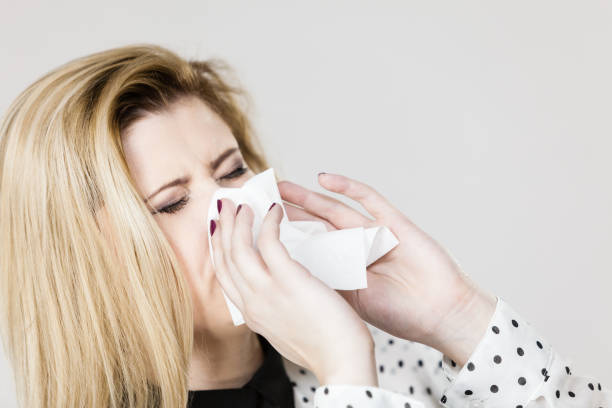 istock Woman being sick having flu sneeze into tissue 844622568