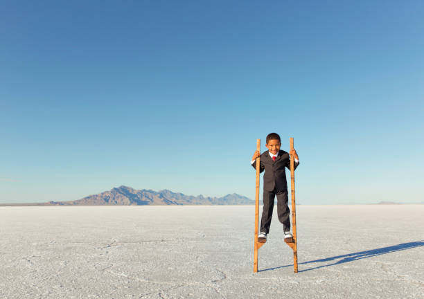 istock Young Businessman Walking on Stilts 844638576