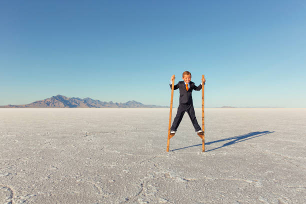 istock Young Business Boy Walking on Stilts 844638614