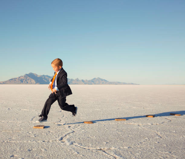 istock Young Business Boy JumpingOn Stepping Stones 844638624