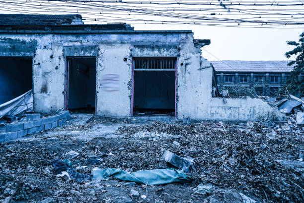 Interior of old factory buildings destroyed. Ruins of industrial enterprise, dark debris destroyed factory premises in factory as result of economic crisis and earthquake.