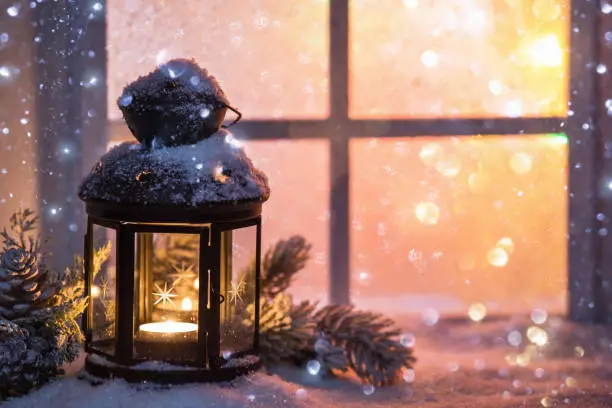 Photo of Winter decoration with a candlestick near the snow-covered window